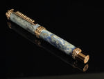 Luxury pen with blue marble pattern and gold accents on a black background