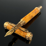 An elegant fountain pen with exotic red coolabah wood and red gold hardware, featuring a cap and finial engraved with a rampant lion.
