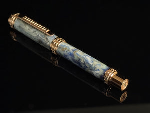 Luxury pen with blue marble pattern and gold accents on a black background