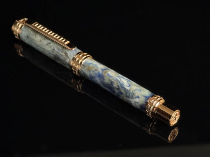 Luxury pen with blue marble pattern and gold accents on a black background