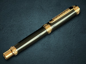 Luxury pen with red gold accents on a dark textured surface