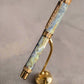 Luxury pen with blue marbled design and gold accents on a black background