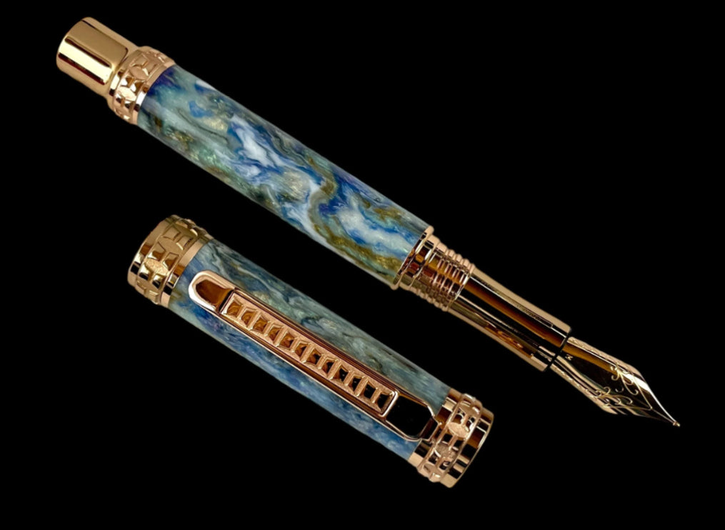 Fountain pen with marbled design and gold accents on a black background